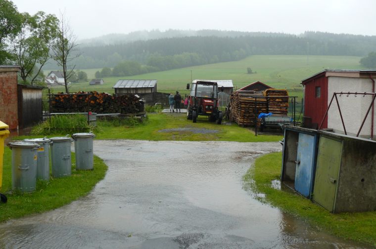 Běžně Děšenický potok teče až tam, kde za traktorem stojí lidé.
